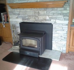 Regency Hearth Heater installed in a manufactured fireplace