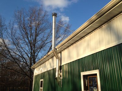 wood stove flue out side of metal building offsetting around eave